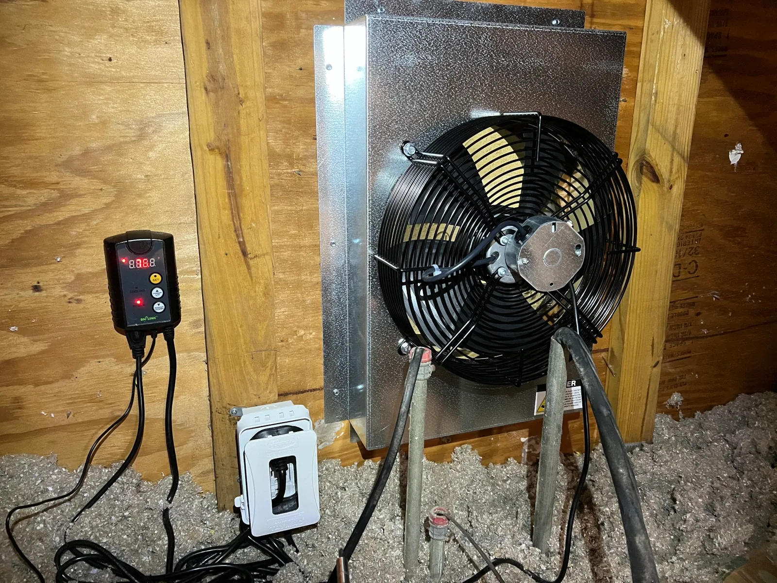 CentricAir gable attic fan installed in the gable opening with thermostat probe mounted nearby