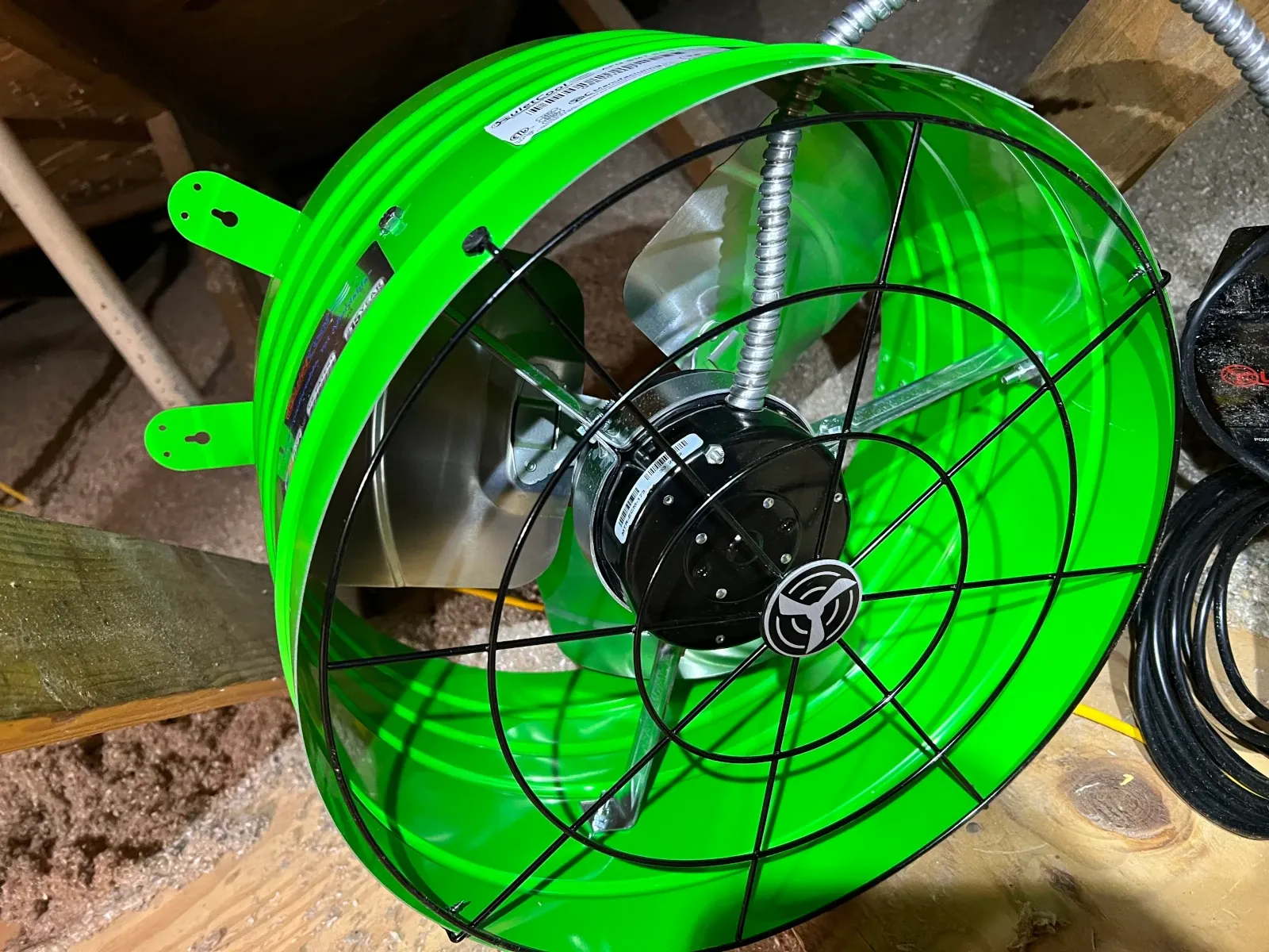 QuietCool gable fan test-fit in the attic opening before it was returned for being too large