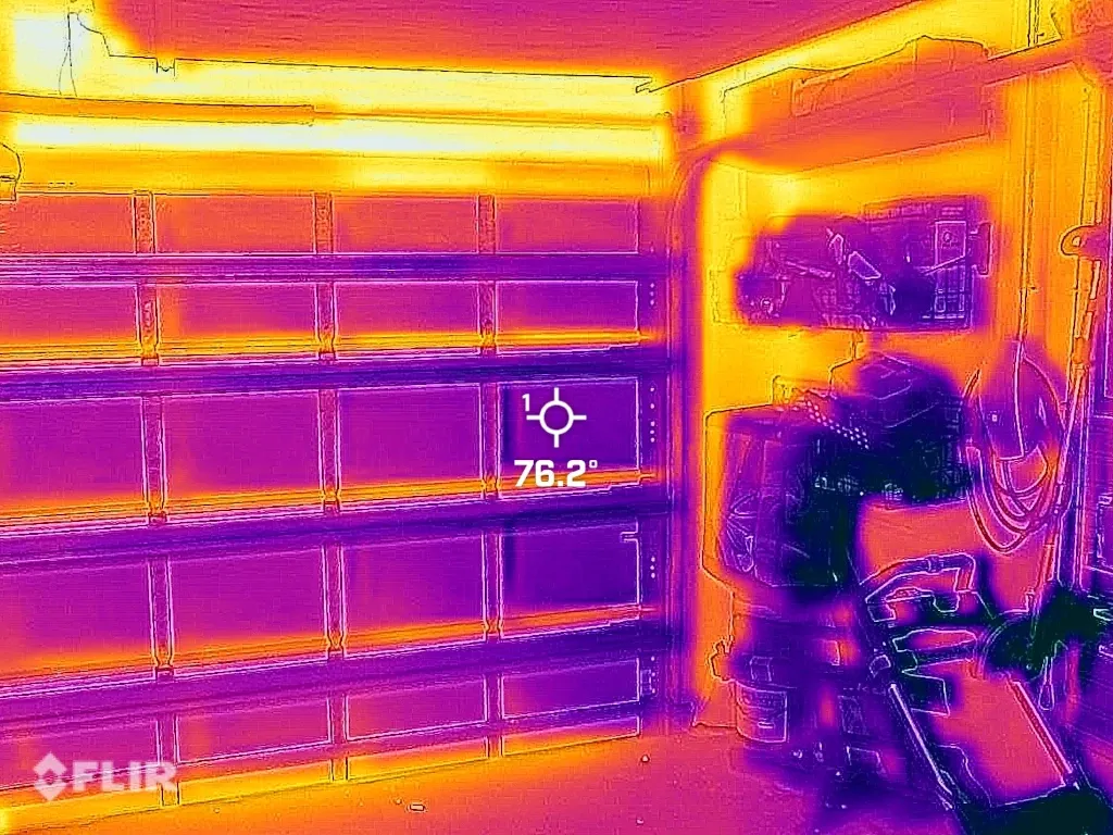 FLIR thermal image of fully insulated garage door with bright orange heat leaking through degraded perimeter weather seal